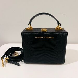 Brandon Blackwood Kendrick Trunk bag in Black lizard-embossed leather.